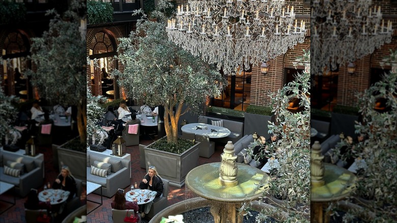 Overlooking brunch setup with crystal chandelier, fountain, and tree