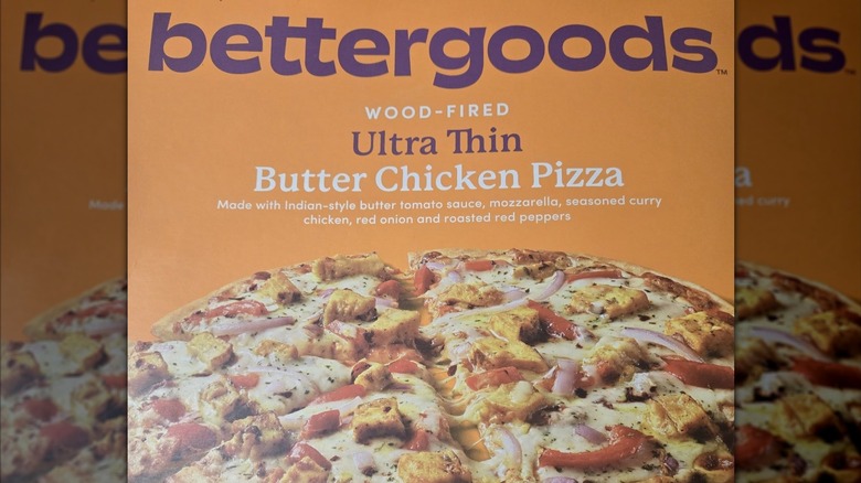 An orange box of bettergoods Wood-Fored Ultra Thin Butter Chicken Pizza