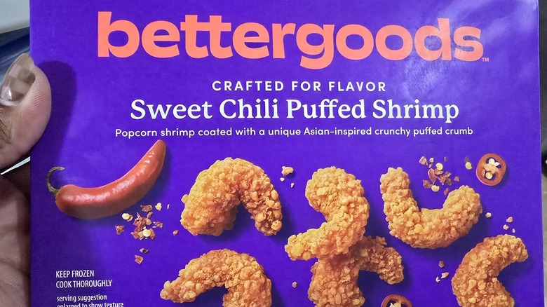 Someone holding a purple box of bettergoods brand sweet chili puffed shrimp