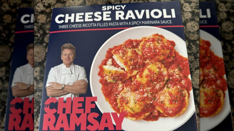 A box of Chef Ramsay Spicy Cheese Ravioli featuring an image of Ramsey next to a bowl of the pasta, sitting on a counter