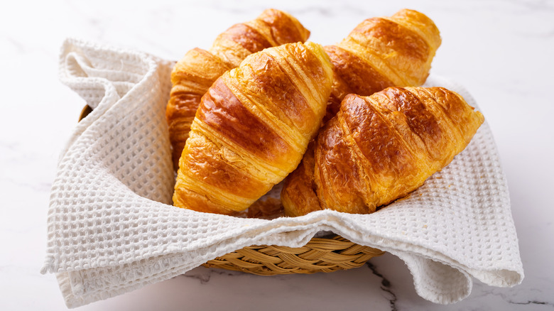 Basket with a white cloth filled with croissants