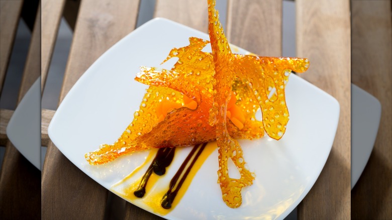 Dessert made with lacy orange sugar work presented on a white plate