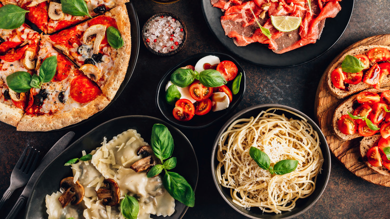 A selection of traditional Italian foods including spaghetti, bruschetta, ravioli, and pizza