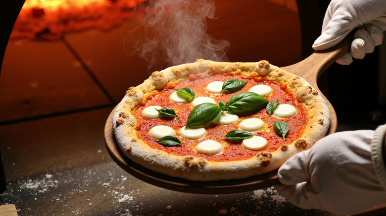 Margherita pizza ready to go into wood fired pizza oven