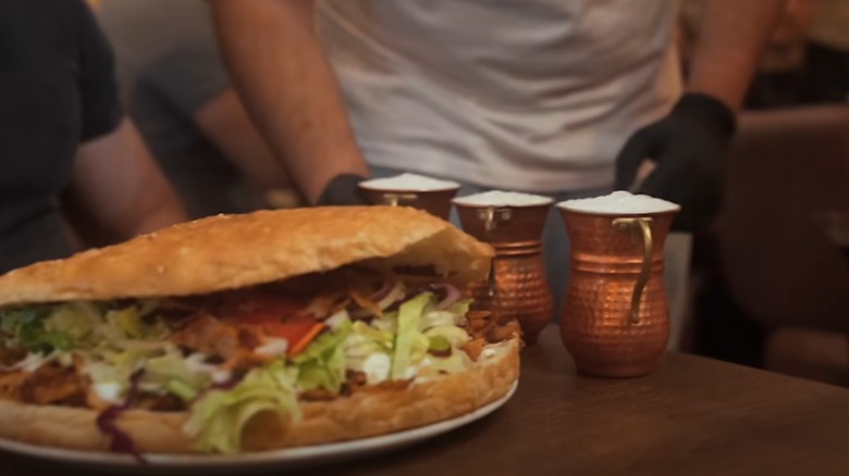 Doner kebap sandwich and three drinks on a table