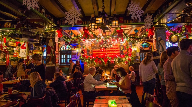 Interior of McGillin's with tables, Christmas decorations, lights, and customers