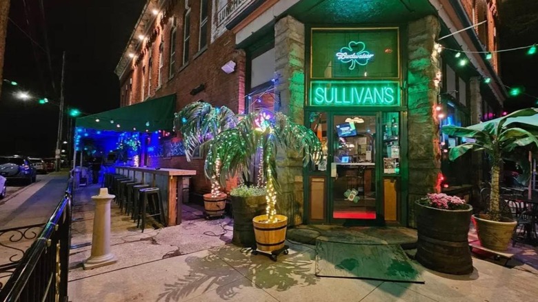 Exterior of Sullivan's with neon lights and potted palm trees