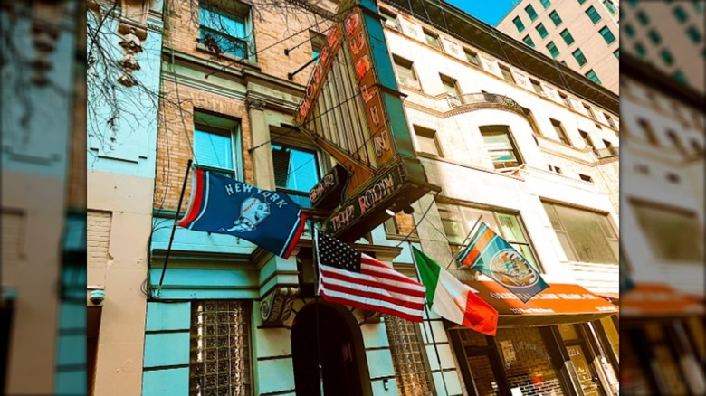 Exterior of The Dublin House with neaon harp sign and flags