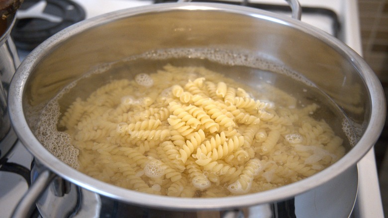 pasta boiling in hot water inside pot on the stove