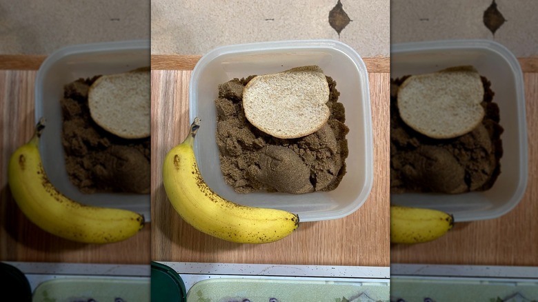 Mirrored image of sugar in a tub with a bit of bread next to a banana