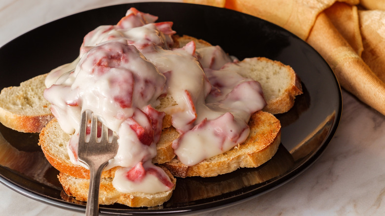 Dish of creamed chipped beef on toast assembled on a black plate