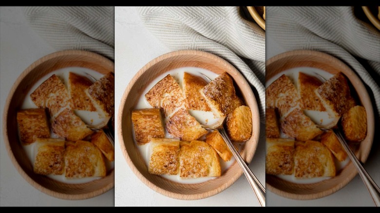Mirrored image of milk toast in a wooden bowl with milk
