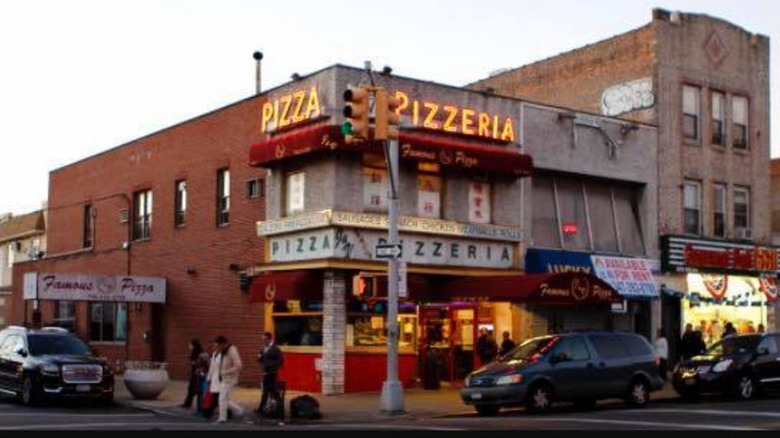 Exteroir of J&V Pizzeria with neon signs on brick building