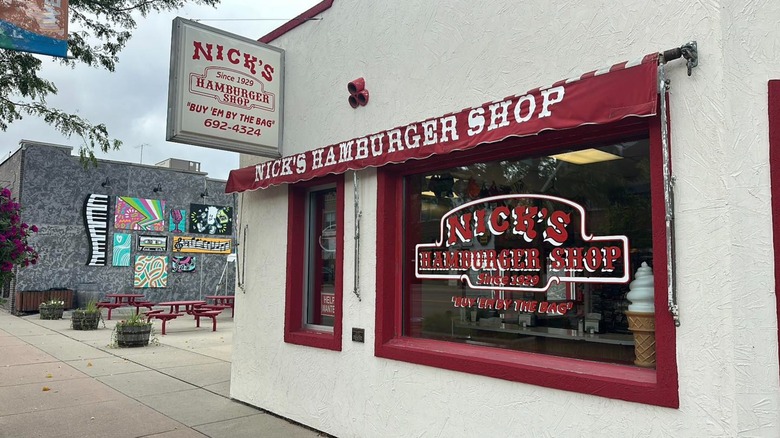 Exterior of Nick's Hamburger Shop white building with red signage
