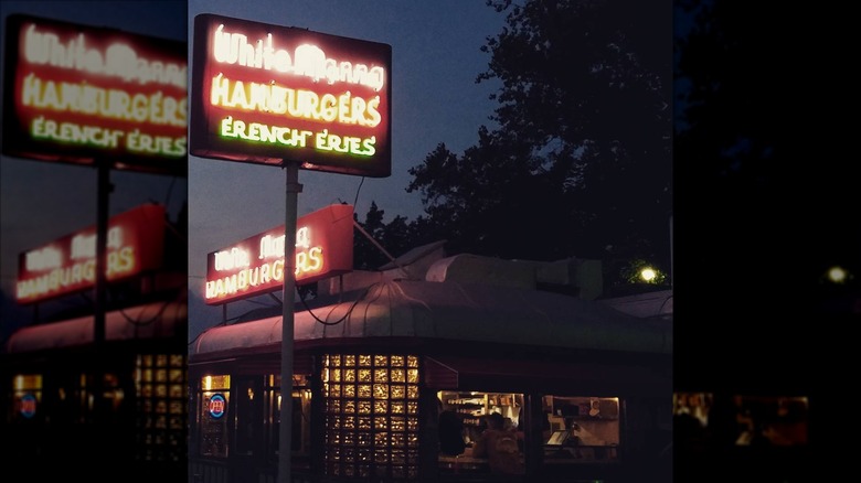 Exterior of White Manna building with neon signs and lights at night