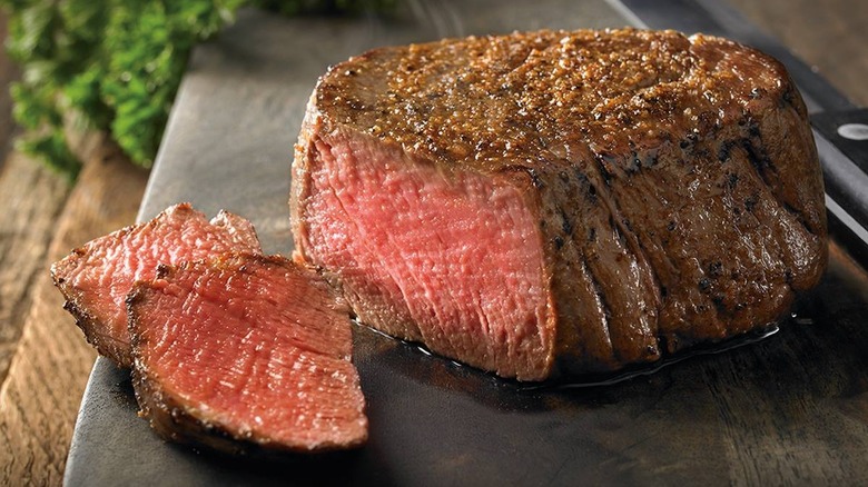 Victoria's Filet Mignon from Outback Steakhouse with two slices taken off sitting on blackboard