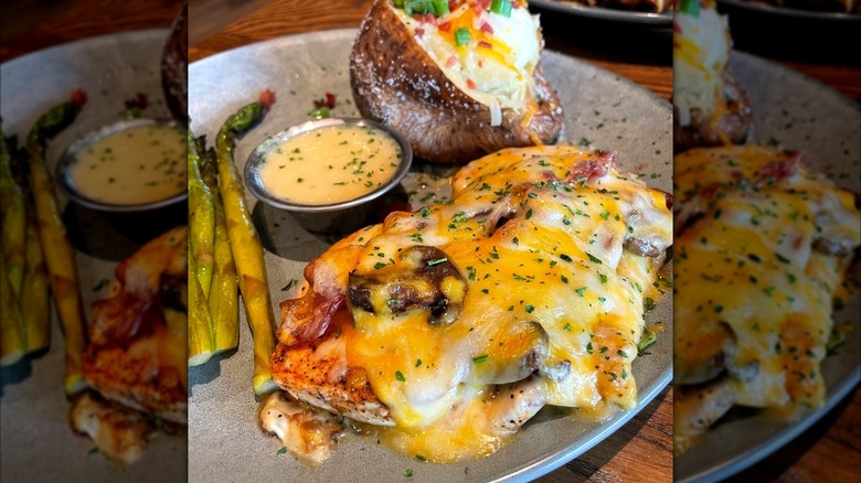 Alice Springs Chicken from Outback Steakhouse next to asparagus, cup of sauce, and loaded backed potato