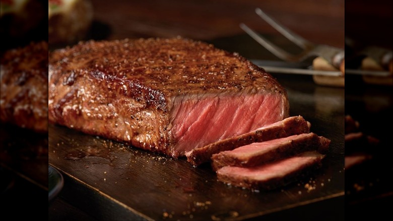 New York strip steak from Outback Steakhouse on dark wood cutting board