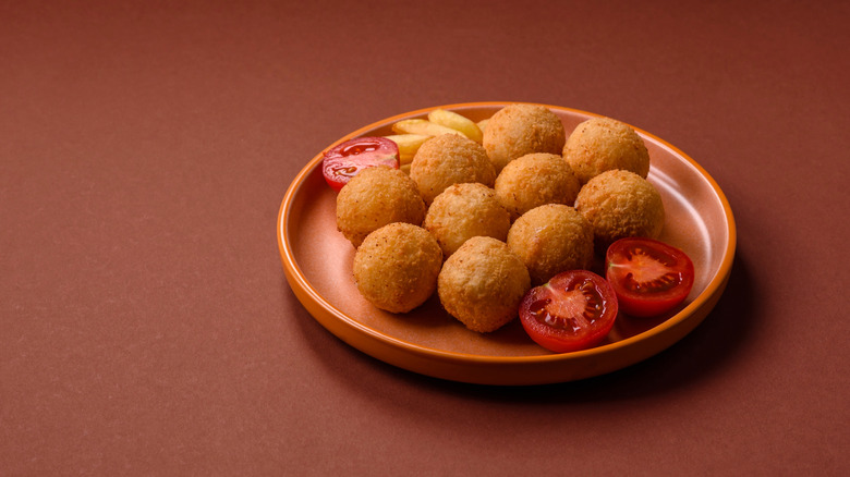 Plate of arancini on red background