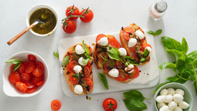 Bruschette on platter with tomato, mozzarella, and basil