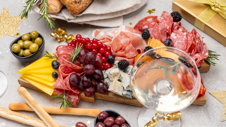Charcuterie board with olives, cheese, fruit, and meat