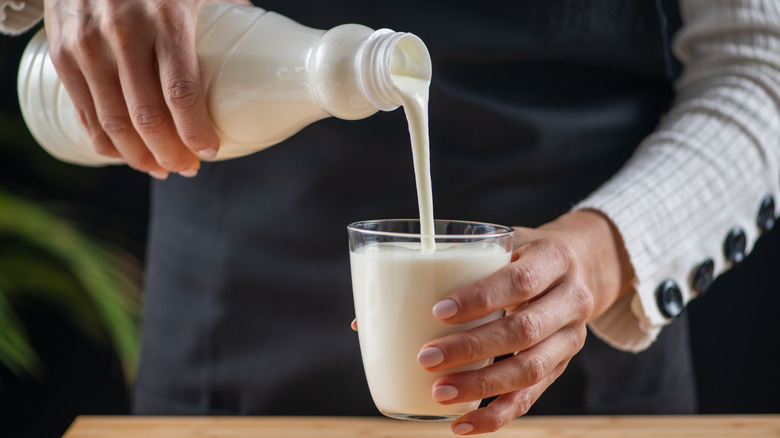 Person pouring kefir into glass