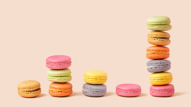 Stacks of brightly colored macarons on pink background