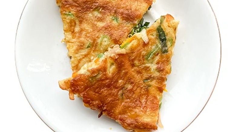 A close-up of egg foo young on a white plate on a white background