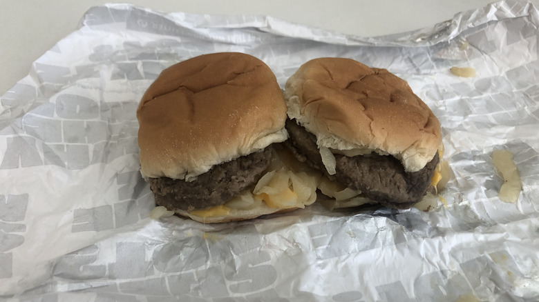Two Sheetz burger sliders with onions and cheese sitting side by side on wrapper