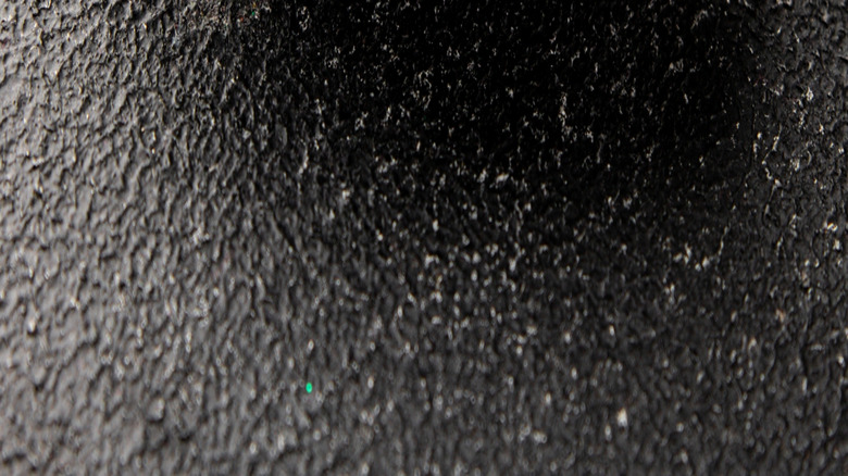 Various types of dried peppercorns in black bowl