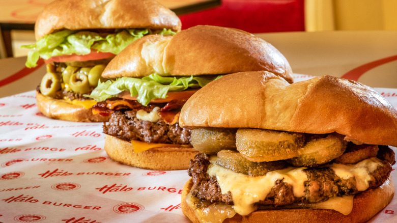 Several hamburgers from Halo Burger atop branded wrapping paper
