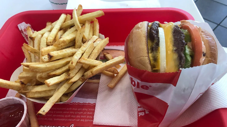 A Double Double and fries from In-N-Out on a red tray