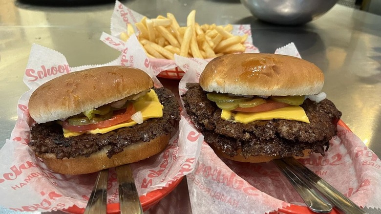 Two smash burgers and fries in baskets from Schoop's Hamburgers