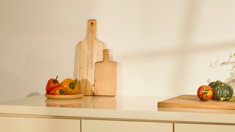 Wooden cutting boards sitting upright against kitchen wall
