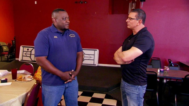 Robert Irvine speaking to Mama Lee's Soul Food owner inside restaurant