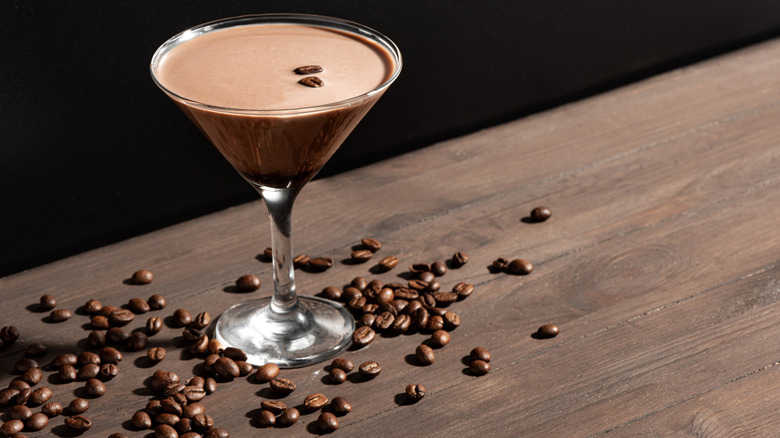 Espresso Martini cocktail with coffee beans on dark background