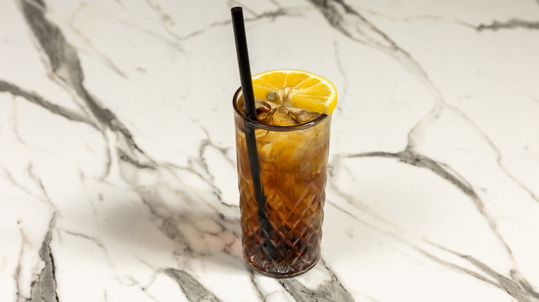 Long Island iced tea in a glass on a marbled surface