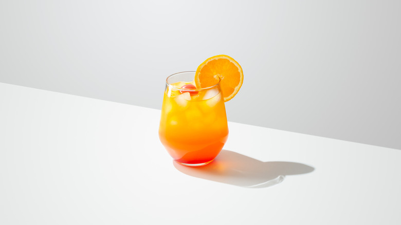 Tequila Sunrise Cocktail with orange slice on table with white background
