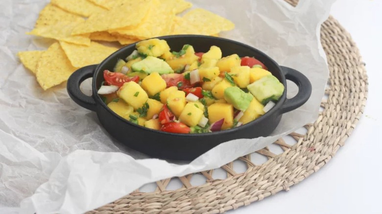 Fresh Mango Salsa in black dish with tortilla chips