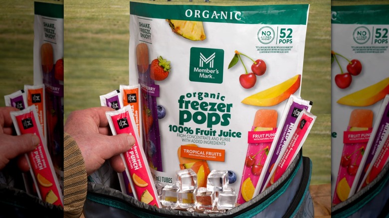 Hand holding Member's Mark Organic Freezer Pops at kids football game