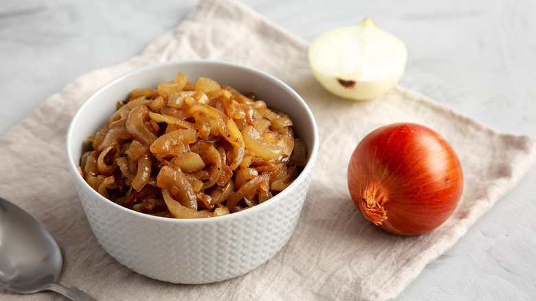 Bowl of caramelized onions with whole fresh onions