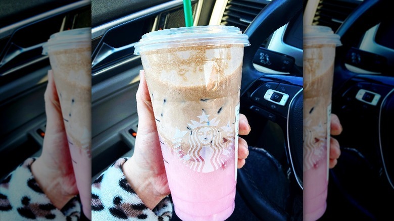 Holding pink and brown drink