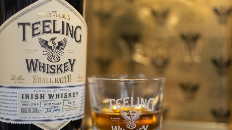 A close up of a bottle and glass of Teeling whiskey, showcasing how it's described as small batch
