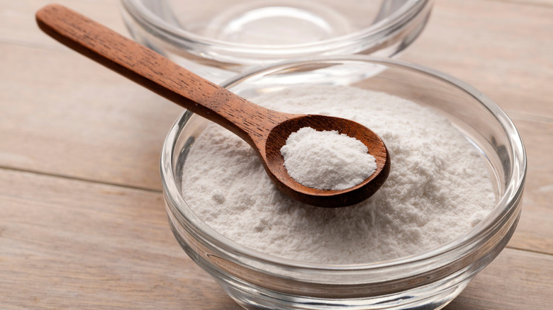 Bowl of baking soda with wooden spoon