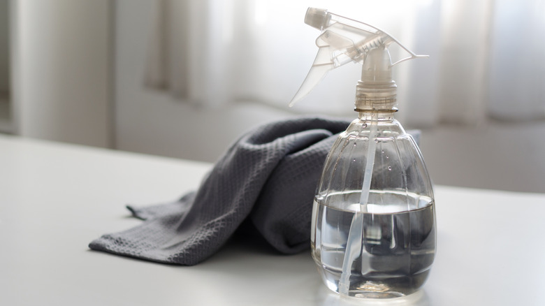 Spray bottle filled with white vinegar solution with cleaning cloth