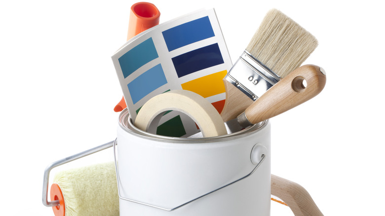 Painting equipment, brushes, and color swatch against a white background