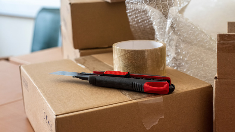 Paper cutter and transparent tape placed on packing box