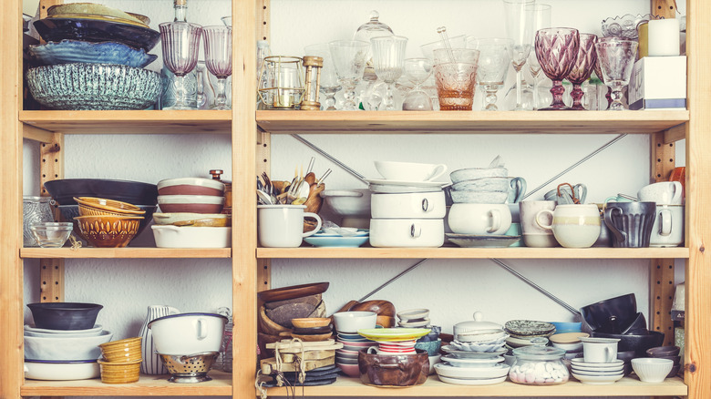 Man removing jars from a kitchen cabinet