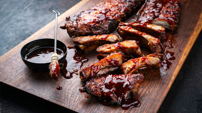 Spare ribs on cutting board, covered with BBQ sauce