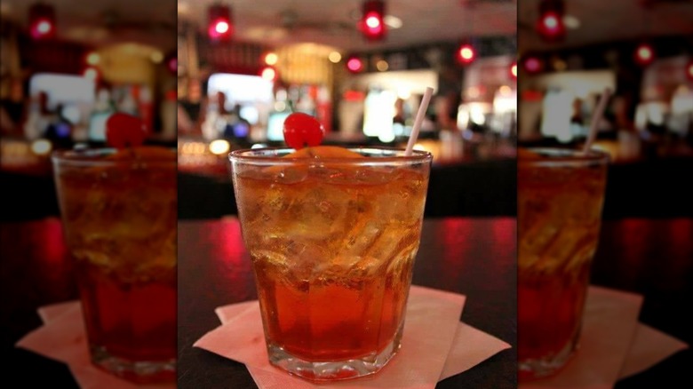 Old Fashioned cocktail sitting on table with background blurred